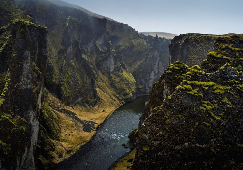 Green moss-covered cliffs above a winding river