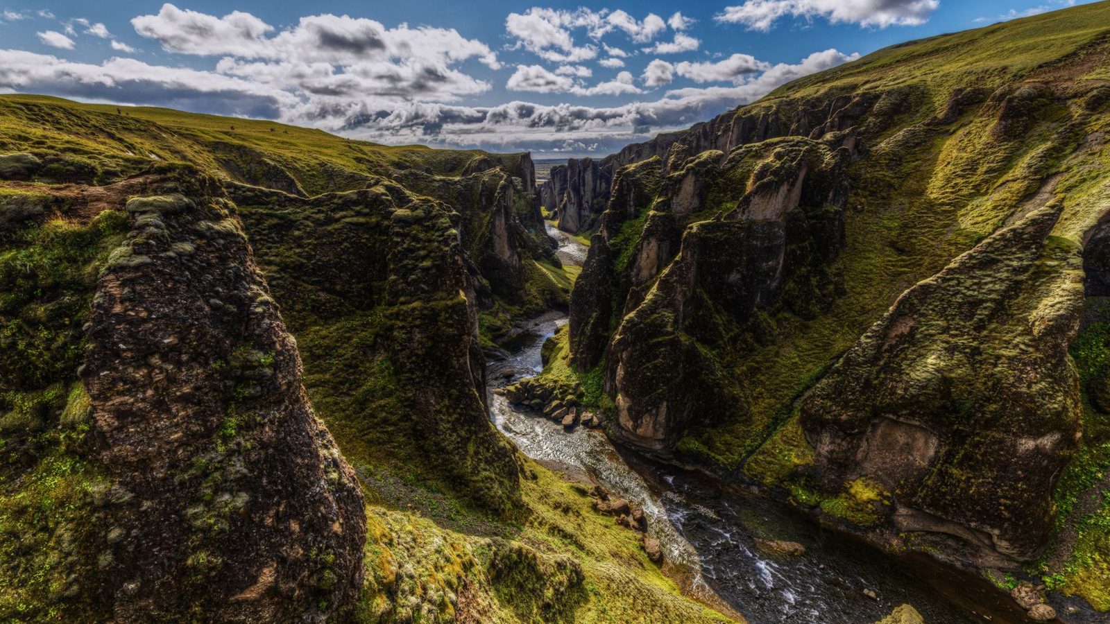 A winding river between moss-covered cliffs in Fjaðrárgljúfur canyon
