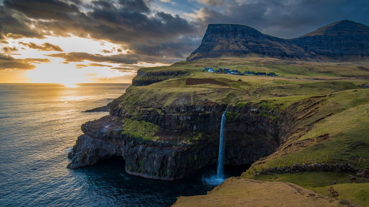 Sunset over the cliffs and the sea near Gásadalur