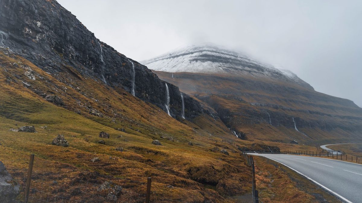 A winding road beside a mountain in the Faroe Islands