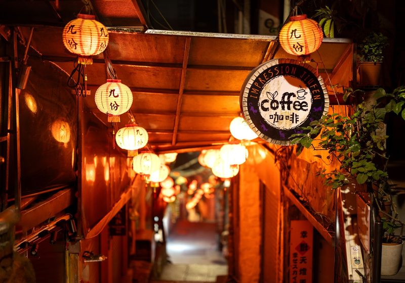 A narrow alley lit by lanterns