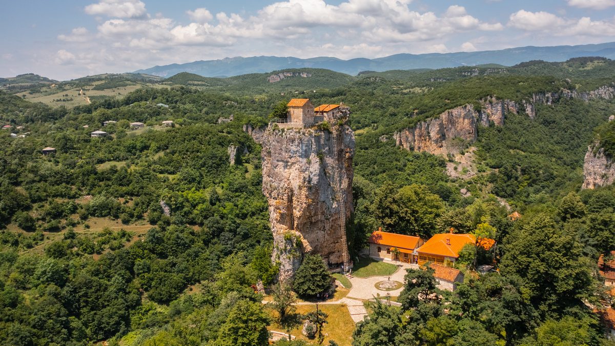 The pillar rising above green hills