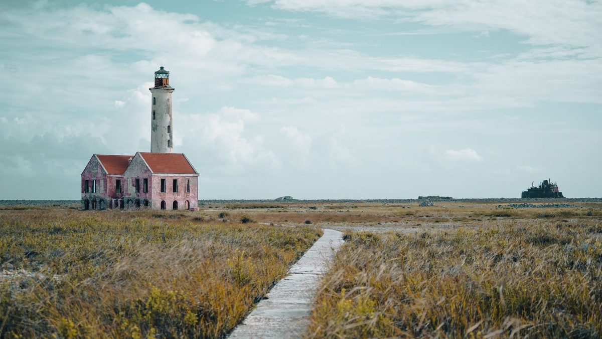 The lighthouse at the end of a path under a pastel sky