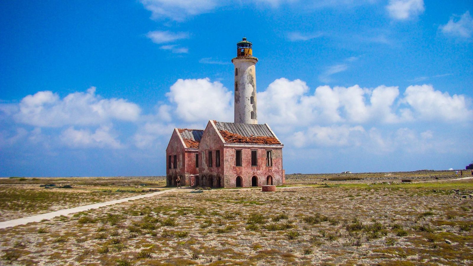 The Klein Curaçao lighthouse and its red-roofed house under a blue sky