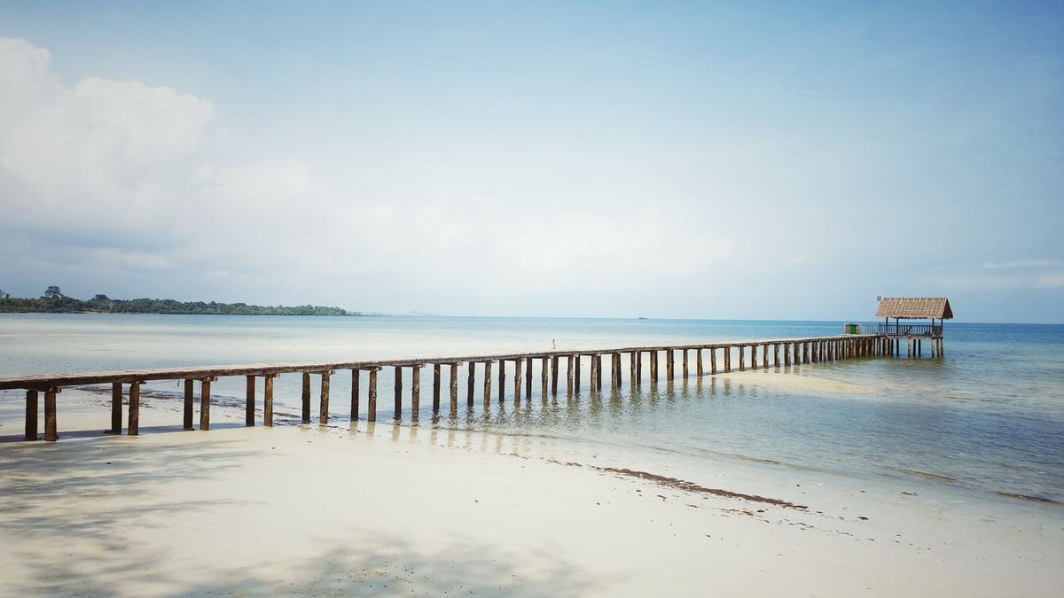 A long wooden pier over a calm sea in Cambodia