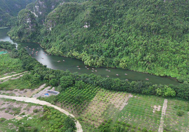 A boat river running past forested karst peaks