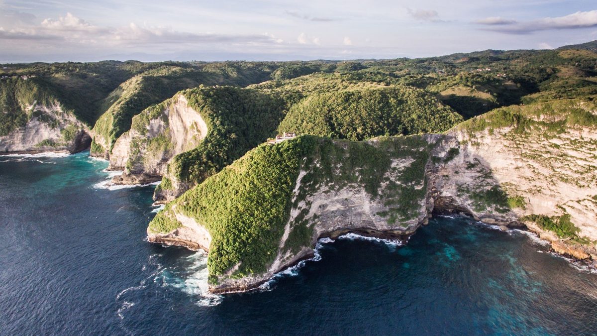 Green cliffs and ocean on Nusa Penida in soft morning light