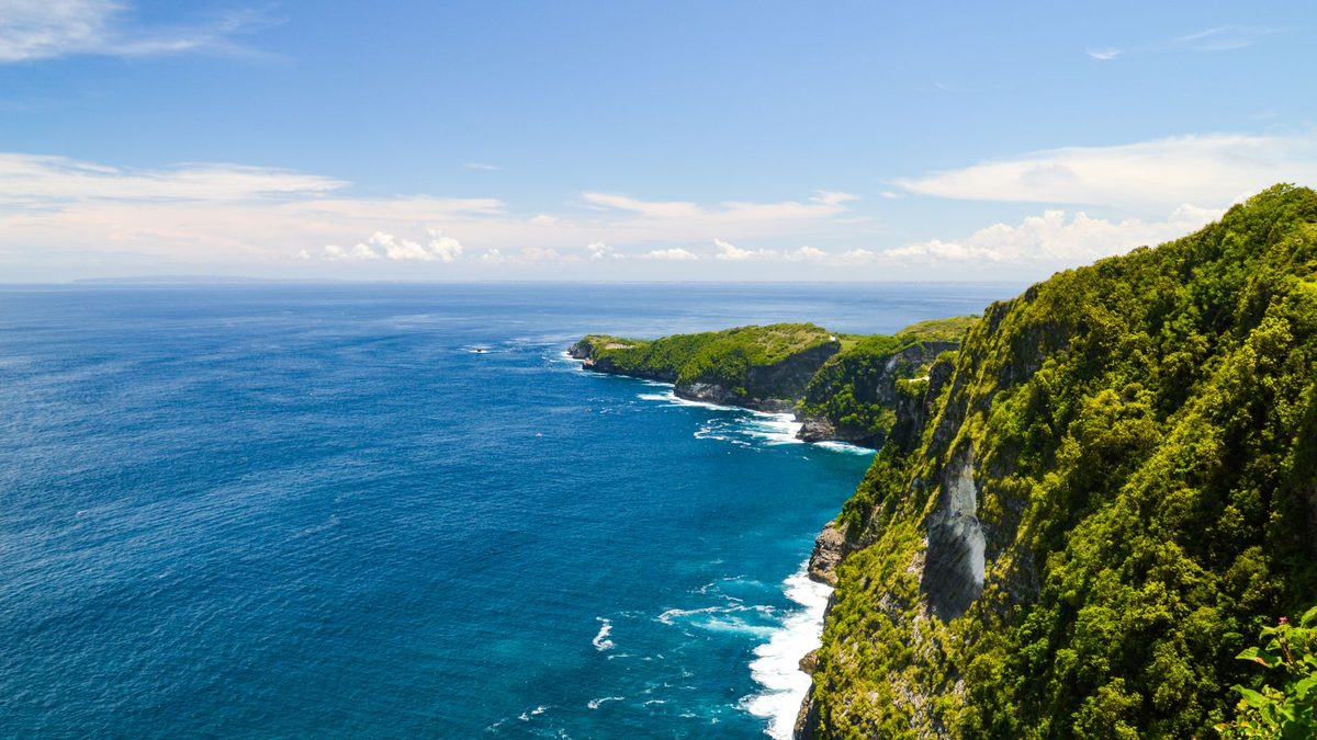 Blue sea and green cliffs on a clear day