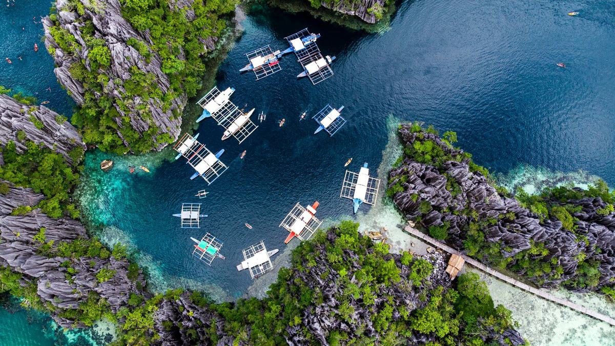 Aerial view of many boats in a turquoise lagoon