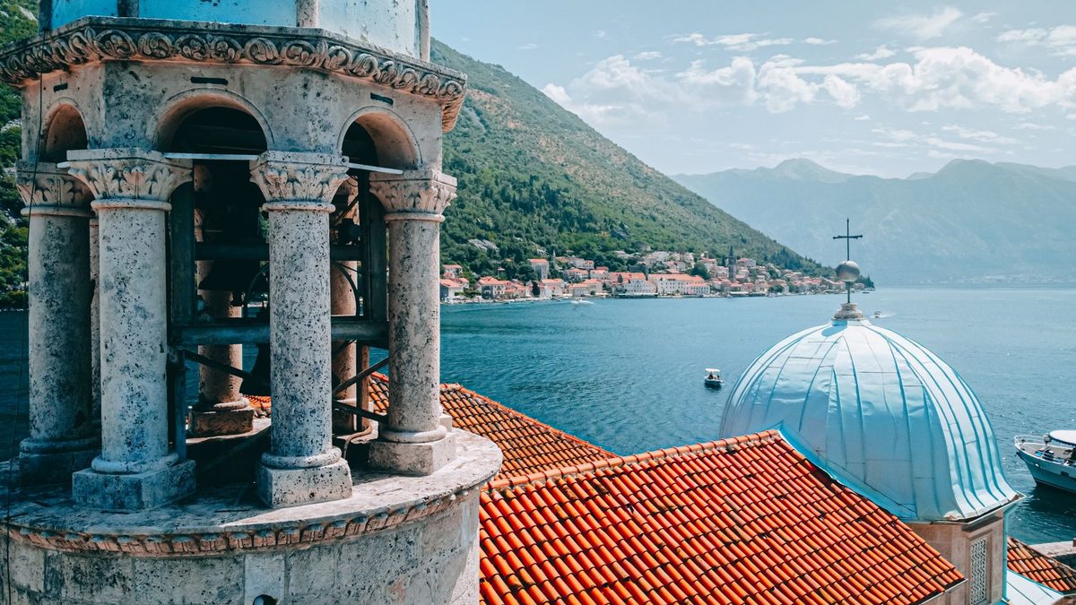 A stone bell tower in Perast above the bay