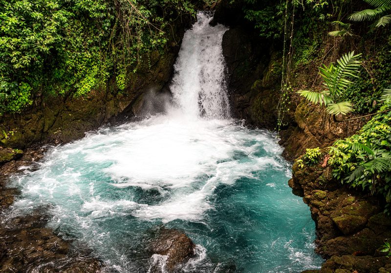 A waterfall dropping into a turquoise pool