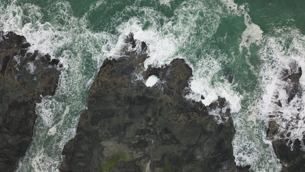 A rocky headland and ocean in warm low light