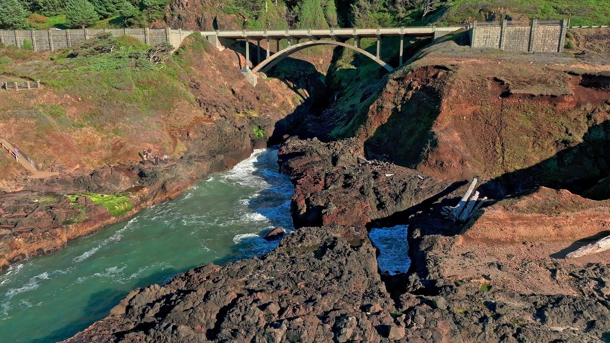 A road bridge over a rocky creek mouth on the coast