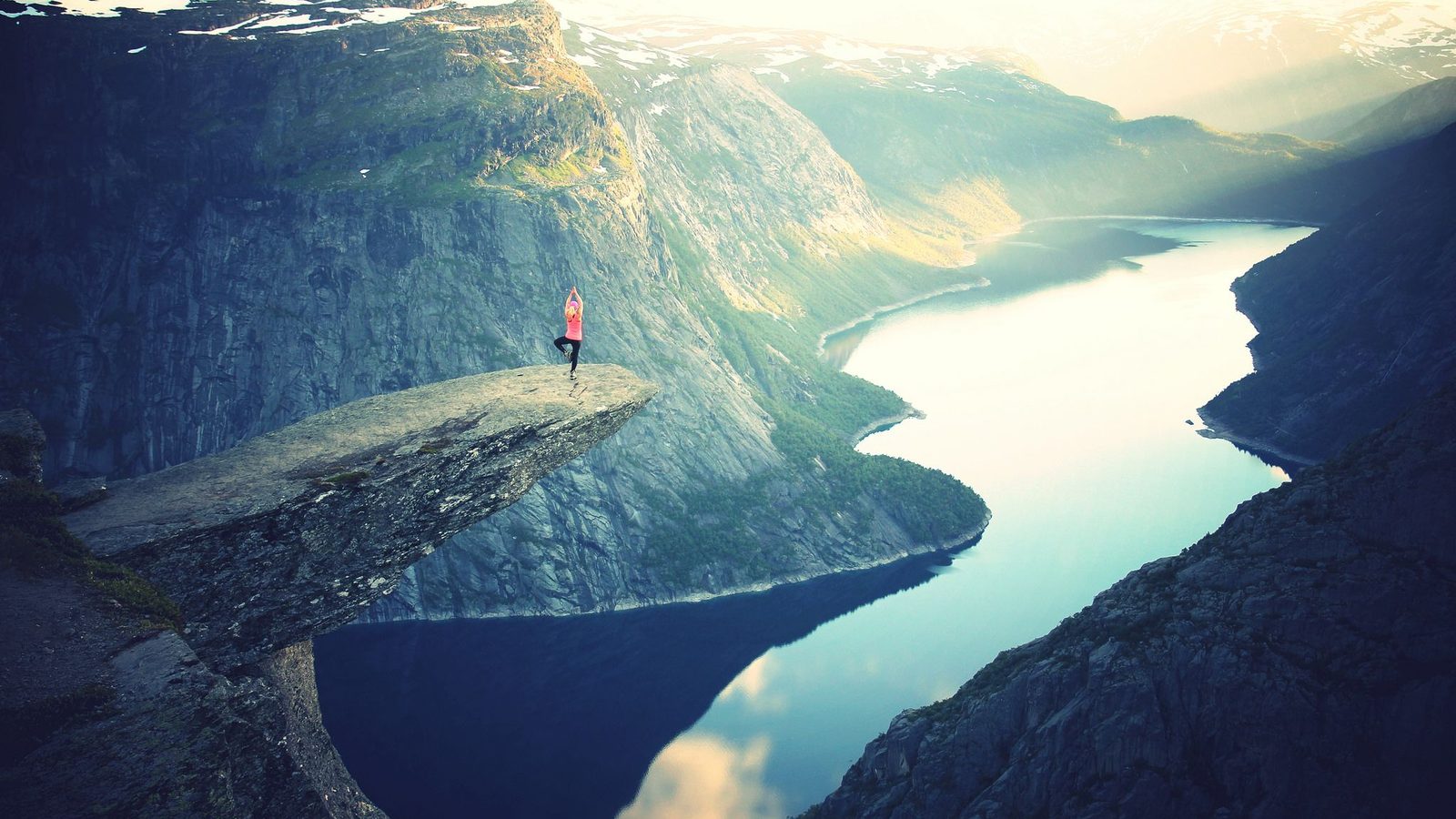 A hiker standing on the Trolltunga rock ledge above Lake Ringedalsvatnet